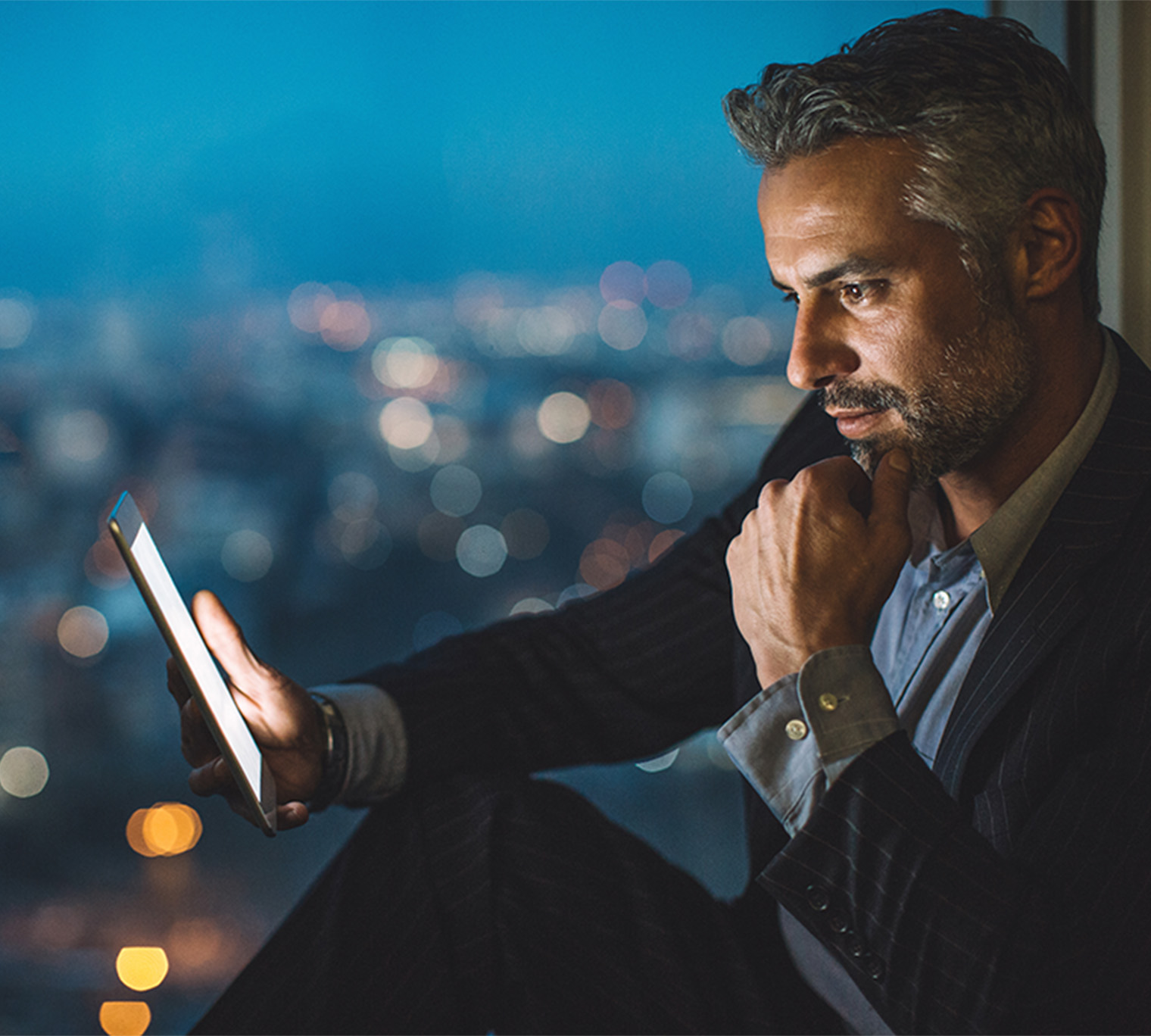 Businessman looking at digital tablet at night