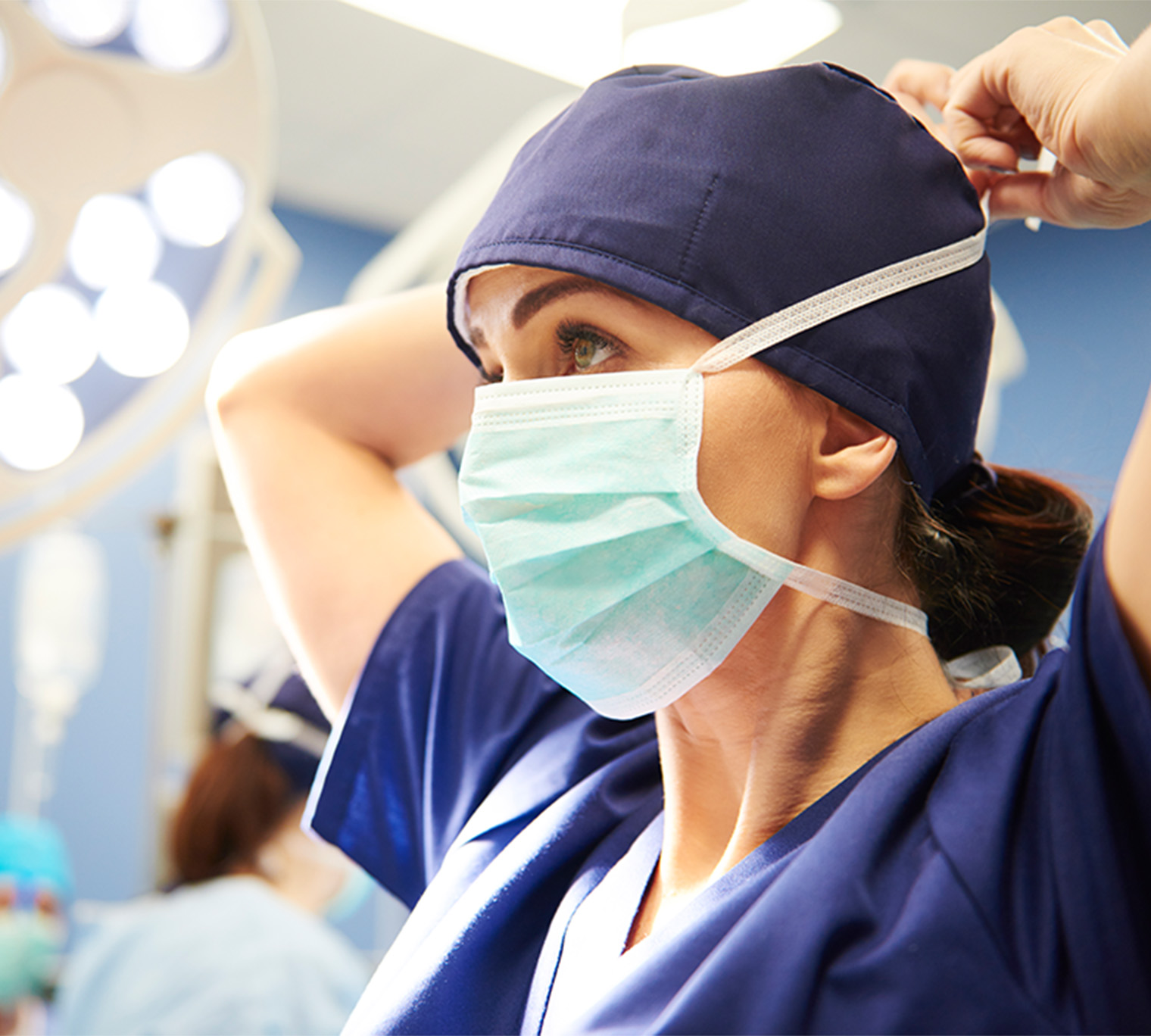 surgeon tying her surgical mask