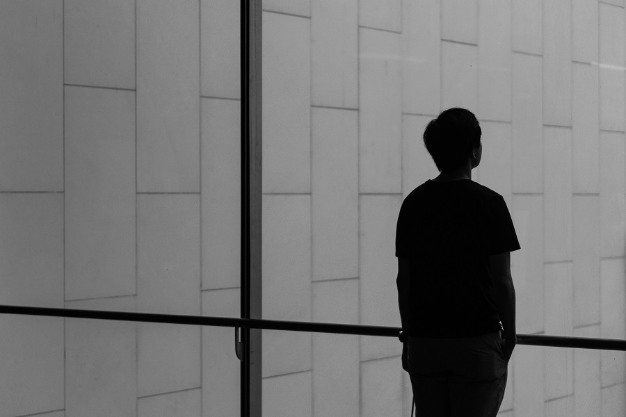 Silhouette of person standing in front of a glass wall