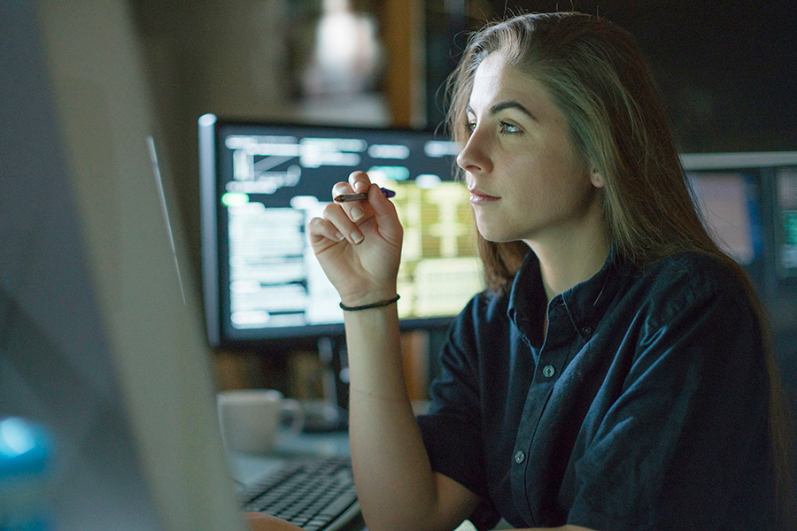 Woman working with several computer screens
