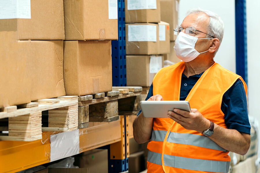 Man with tablet taking inventory in warehouse