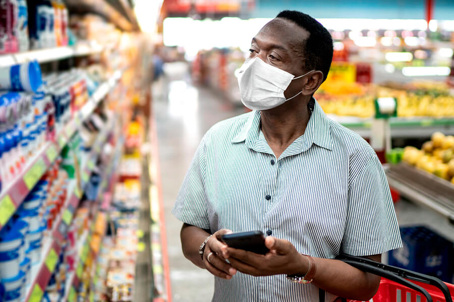 Masked man grocery shopping