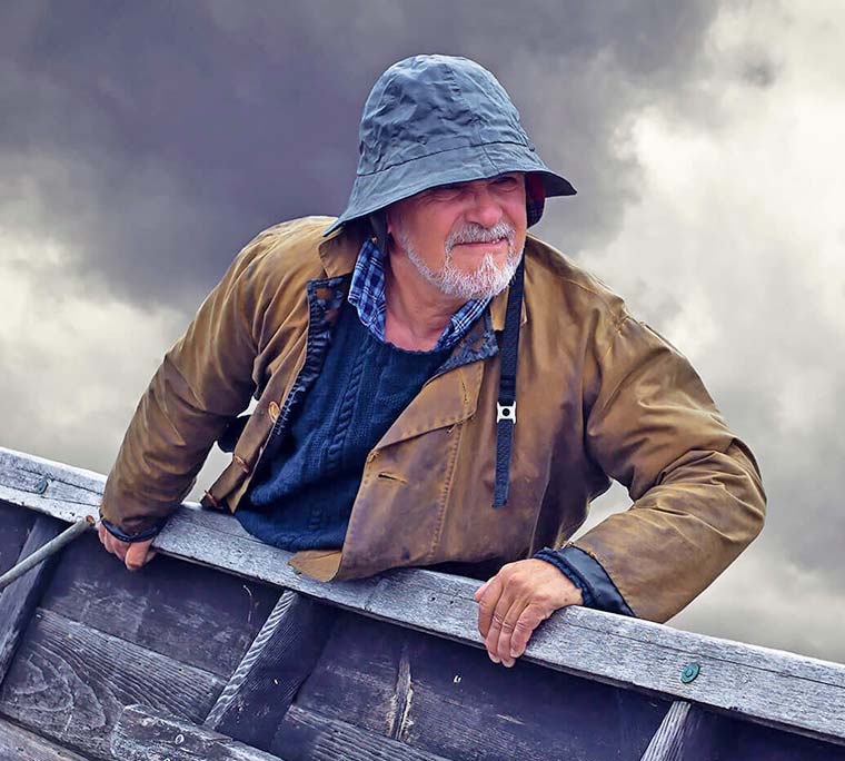 Portrait of a fisherman with stormy sky and dory