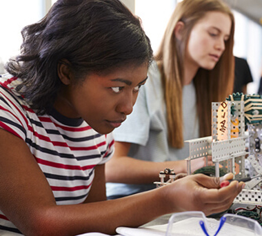 Two girls learning to build technological devices