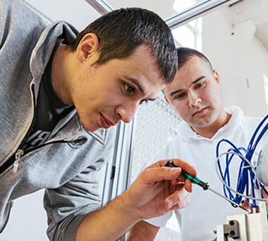 Two men fixing electronic equipment