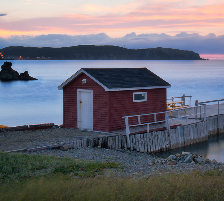 a boathouse set against an east coast sunset