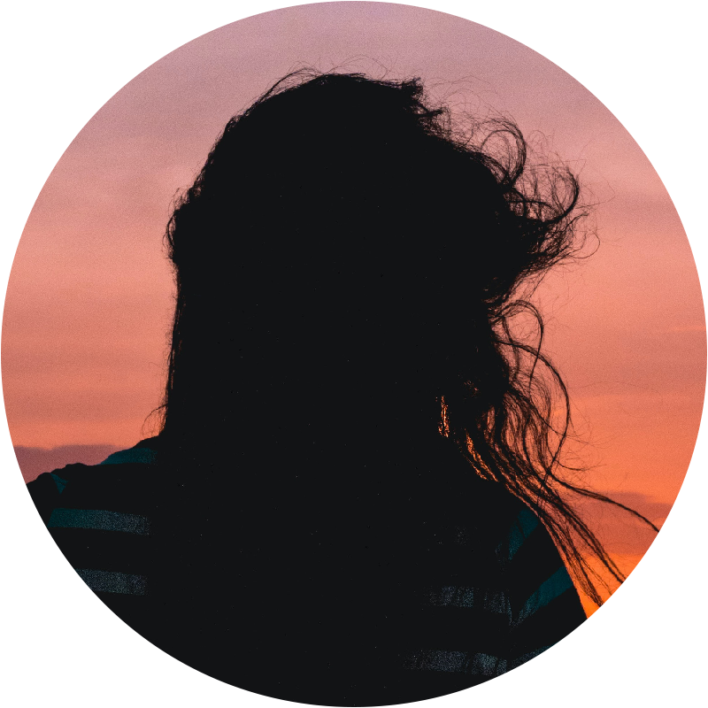 silhouette of a person with a long haired person with a pink coloured sky 