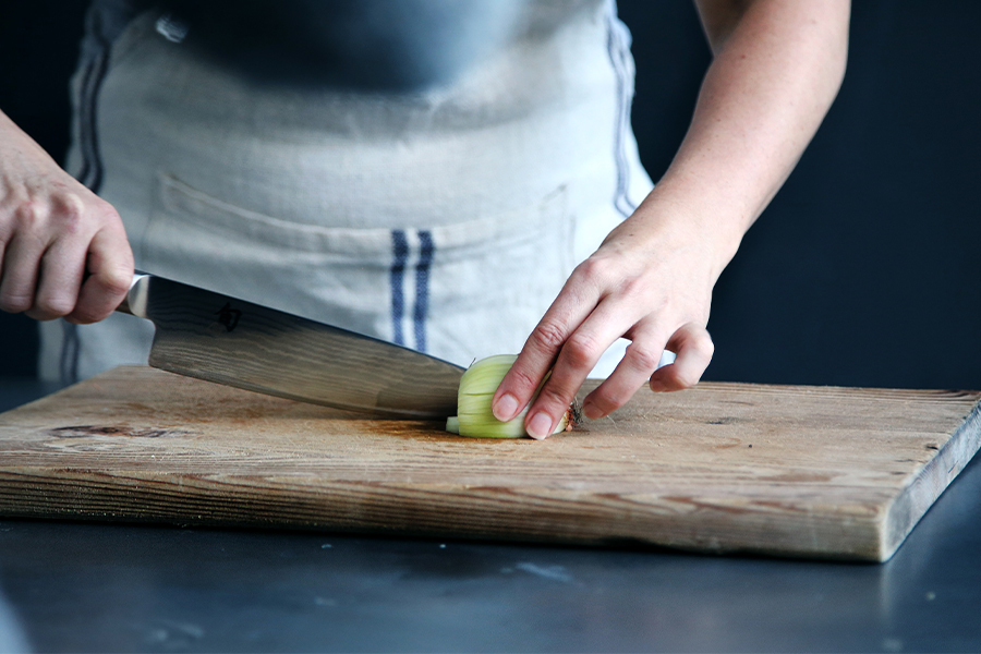 Chef chopping onion on cutting board