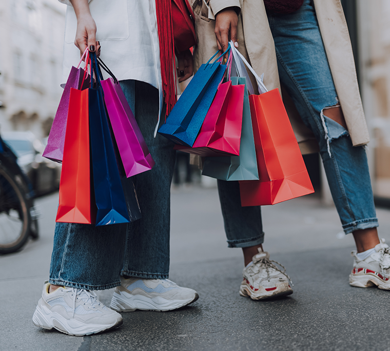 two women with shopping bags standing on the street