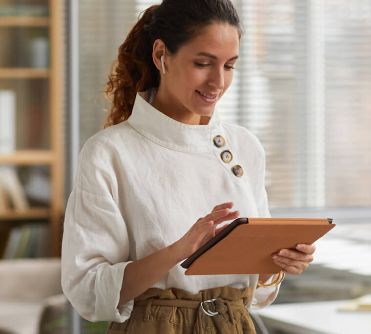 Woman standing working on tablet