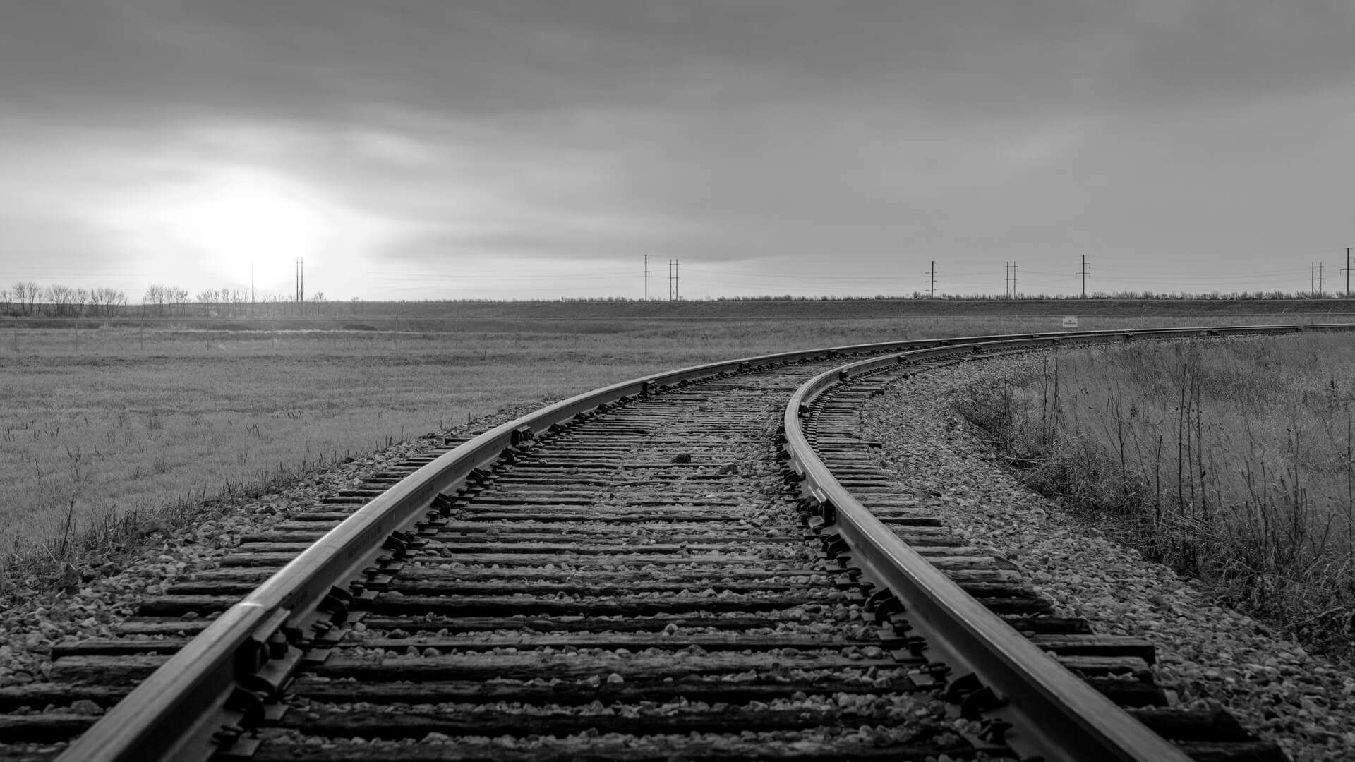 Train tracks bearing right in an empty landscape