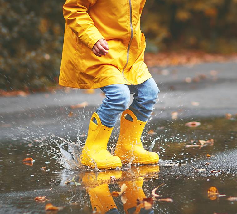 a kid is splashing in a puddle