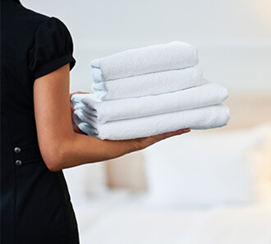 Hotel maid holing stack of towels