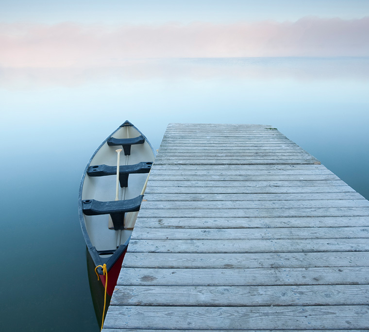 Canoe at rest on a calm foggy day at Riding Mountain National Park, Manitoba.