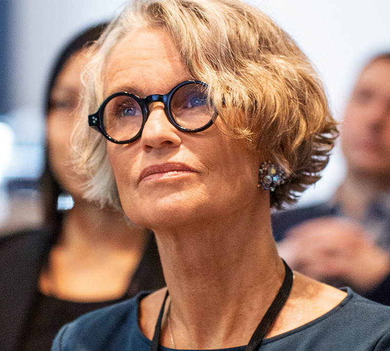 An older woman looks inquisitive during a corporate presentation